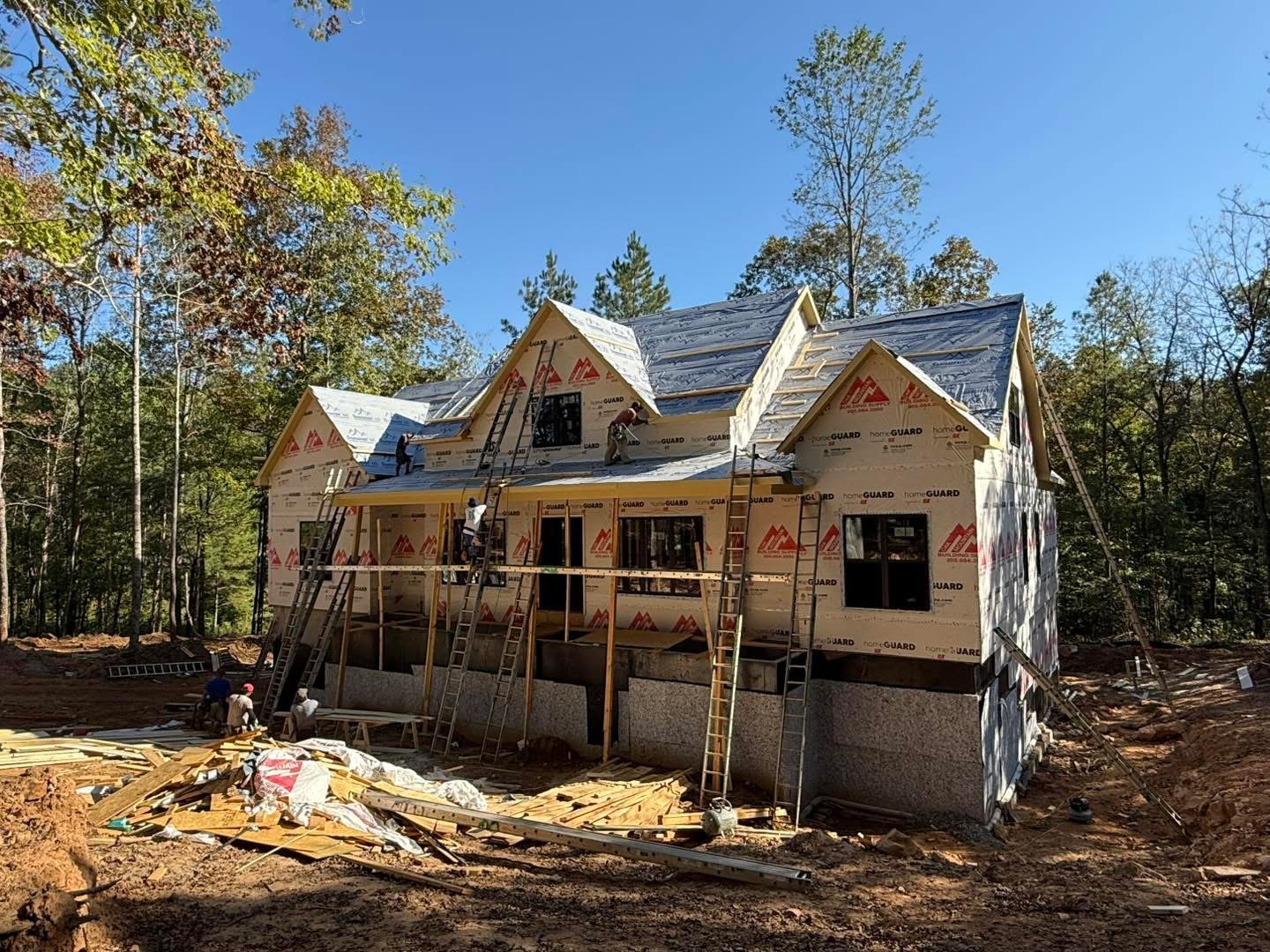 Framed lakefront home wrapped and ready for roofing installation