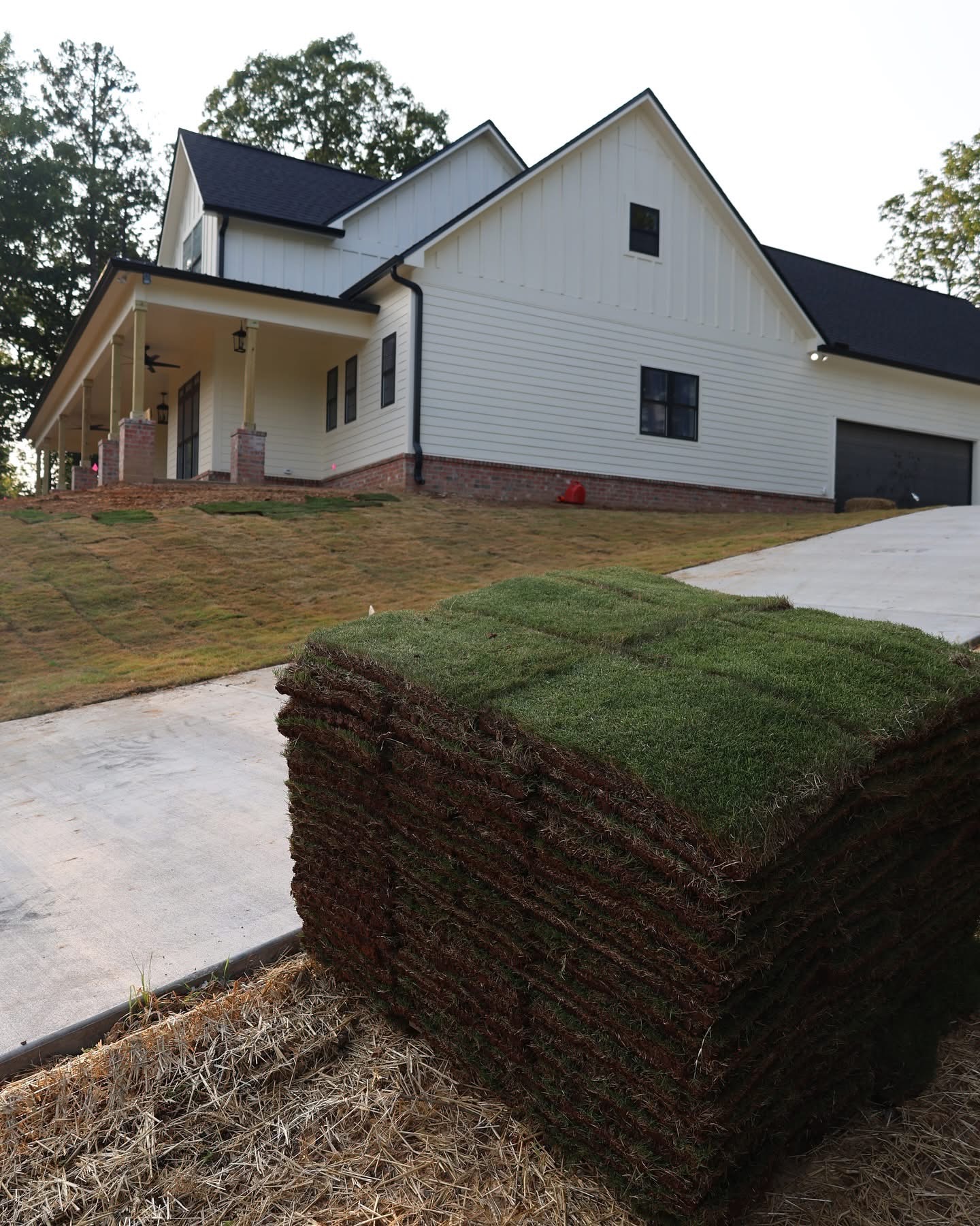 Fresh sod installation around the finished modern farmhouse