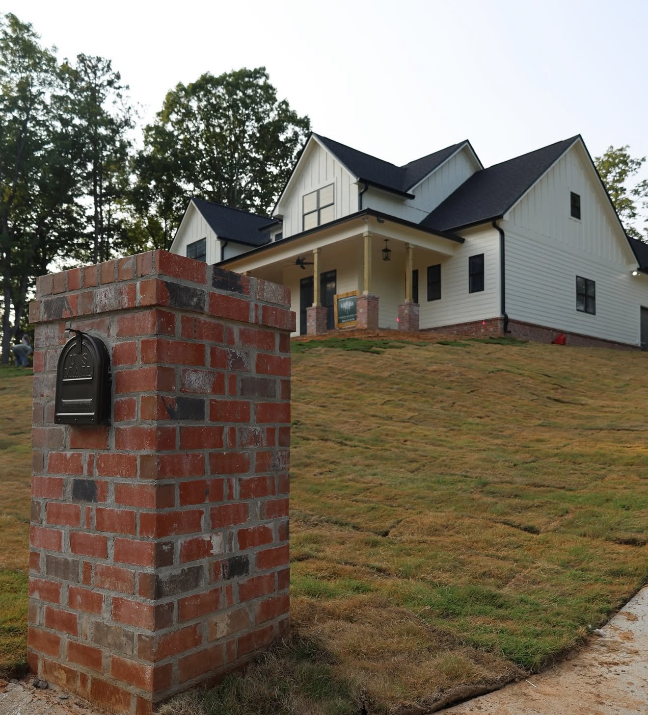 Front view of the completed modern farmhouse in Trussville with new sod, driveway, and a brick mailbox