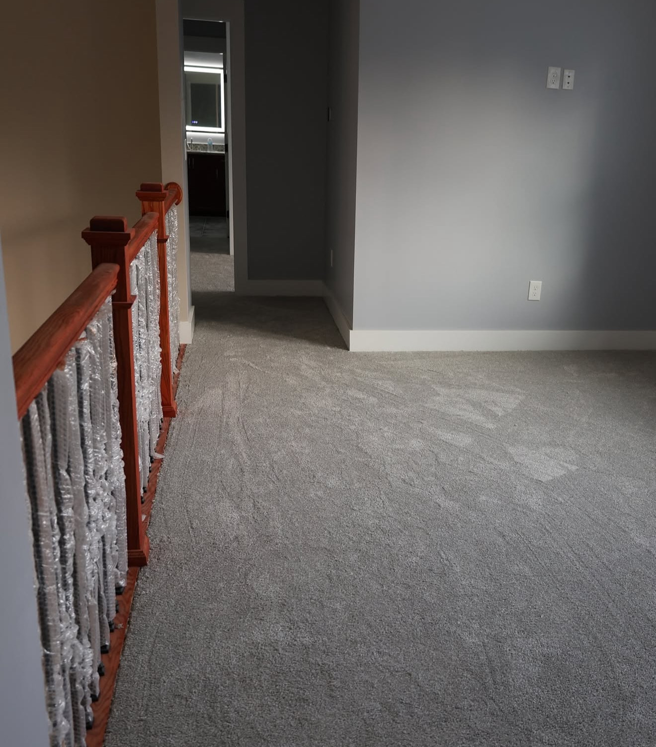 Upstairs hallway view featuring soft neutral carpet and natural light in the modern farmhouse